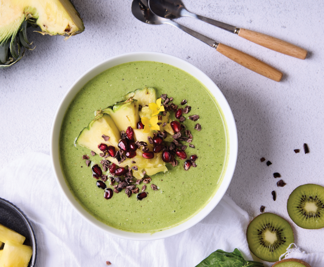Green healthy glow smoothie bowl with kiwi, pineapple, cacao nibs and pomegranate seeds, Fully in Balance recipe by Dalia Brunschwig